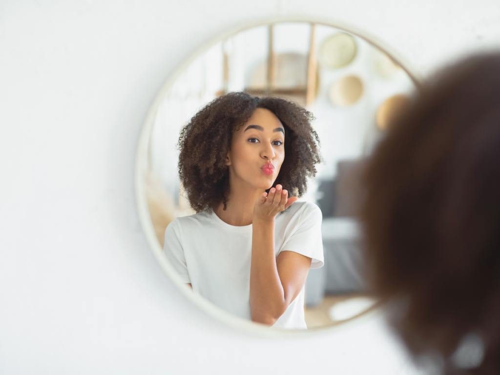 Woman looking in the mirror feeling confident 