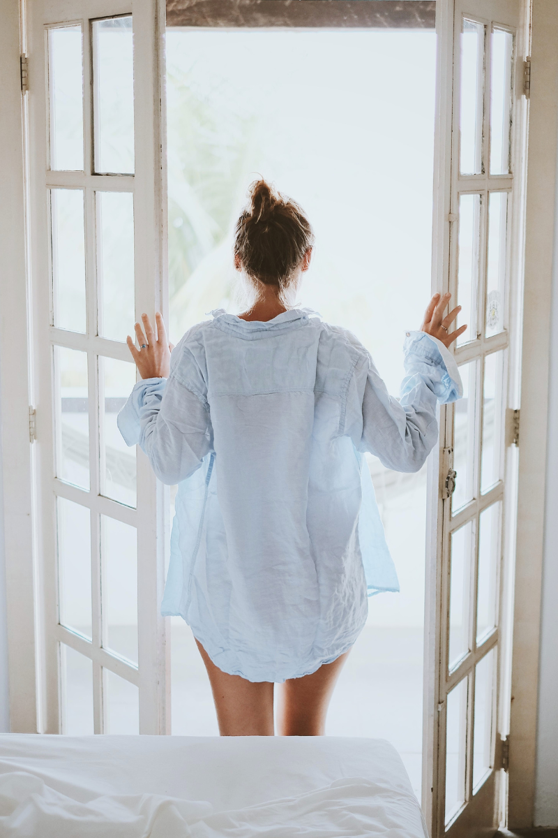 Woman being mindful in morning while opening doors